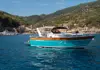 Turquoise Italian Riviera motorboat cruising off the coast of Monterosso al Mare in Cinque Terre.