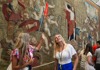 A tourist isnide the Hall of Tapestries with her guide from The Tour Guy.