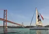 Sailboat passing under the 25 de Abril Bridge in Lisbon