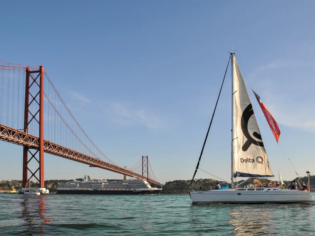 Sailboat passing under the 25 de Abril Bridge in Lisbon