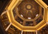 An intricately designed octagonal ceiling with gilded details and frescoes, showcasing the grandeur of church architecture.