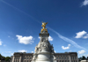 Statue with a golden angel on top of other victorian figures in front of Buckingham Palace in a large public square