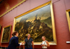 A tourist taking a picture of Venus di Milo in the Louvre Museum while on tour with The Tour Guy.