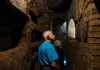 a tourist admiring Domitillas Catacombs hallways in Rome