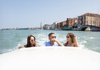 A group of tourists taking a selfie while on a Gondola ride in Venice.