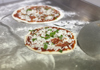 Pizzas on steel flattop