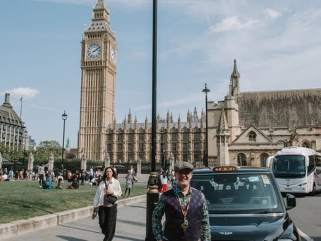 A traditional London Black Cab parked in front of Big Ben.