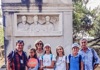 People standing in front of an ancient monument on the Appian Way