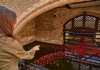 A man standing in front of the entrance to the Crown Jewels in the London Tower while speaking to his guide from The Tour Guy.