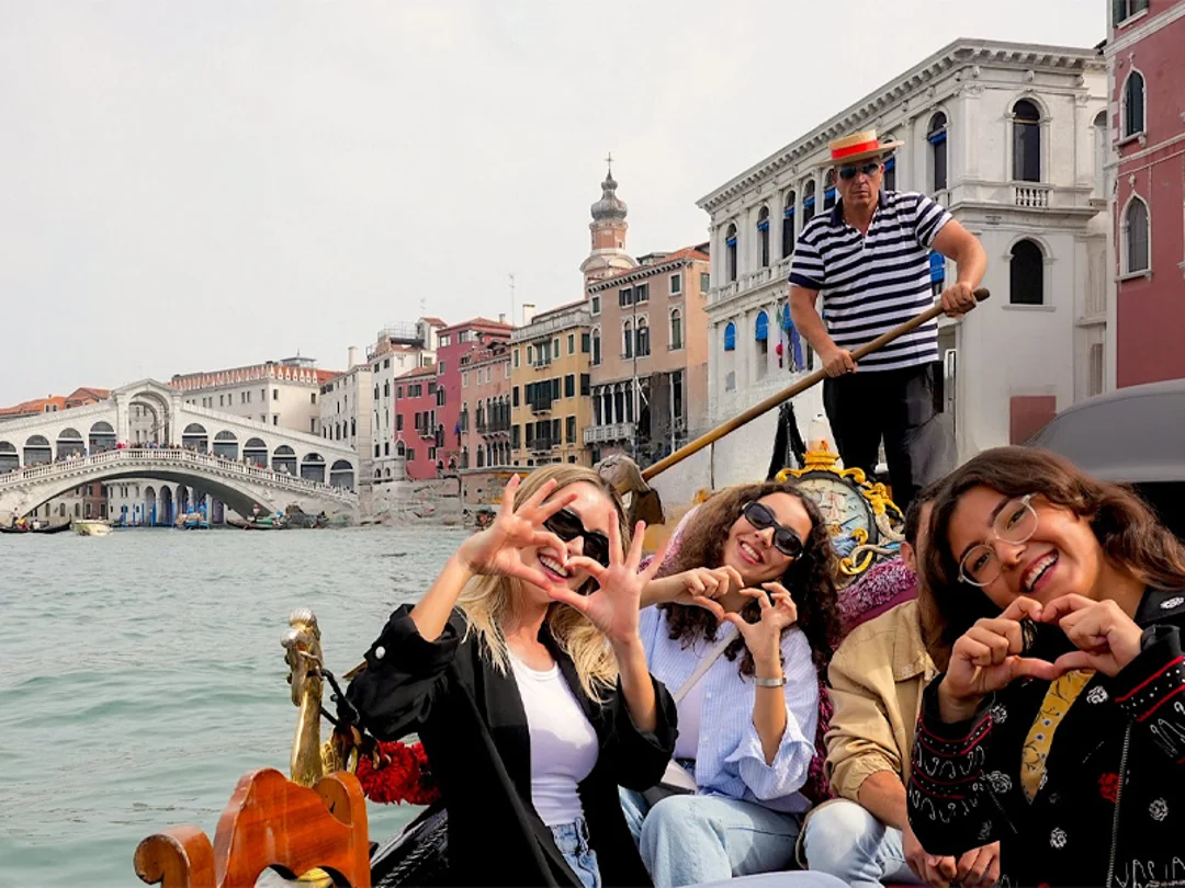 A family sitting on a gondola in Venice.