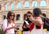 Two women listen attentively to their tour guide outside the Colosseum, holding guidebooks and maps.
