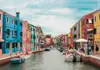 Scenic canal in Burano lined with brightly colored houses and small boats