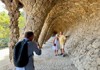 A picture of a couple getting their picture taken by a tour guide inside of Park Guell in Barcelona. 