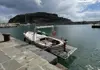 Traditional wooden boat docked at a stone pier inside a quiet marina