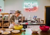 A person mixing pasta in a bowl preparing for dinner