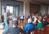Wine expert speaking to a seated group inside a tasting room during a vineyard tour.