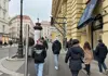 Group of people walking along a shopping street in Vienna on a cold day.
