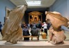 A picture of tourists looking at artwork inside of the British Museum in London.