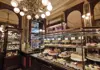 Display case filled with cakes and pastries inside an ornate Viennese café.