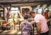 Father and son reading signs in front of a replica of the Weasley kitchen 