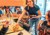 Waitress serving escargot to a group in Paris