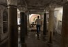 An image of a tourist walking towards The Mouth of Truth inside Hadrian's Crypt in Rome. 