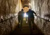 Visitors climbing stone stairs exiting the Roman catacombs