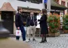 Guide speaking with two participants outside a traditional restaurant during a food tour.