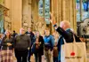 a guide explaining about the Westminster Abbey to a group of tourists