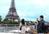 A couple on the Eiffel Tower's 2nd level at night.