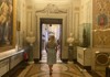 A female tourist walking through the halls of the Borghese Gallery.