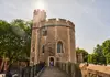 A group of tourists walking inside the Tower of London.