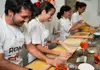 A group of women in aprons drinking spritz at a cooking class