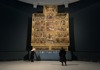 An image of tourists looking at. Raphael's Cartoons inside of the Victoria and Albert Museum in London. 