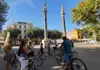 Cycling tour group gathered around their guide at Alameda de Hércules in Seville, with the historic columns behind them.