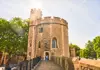 A group of tourists walking inside the Tower of London.