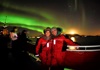 couple posing for picture on boat with northern lights