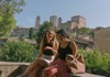 A couple of tourists sitting on a wall in San Gimignano, Italy.