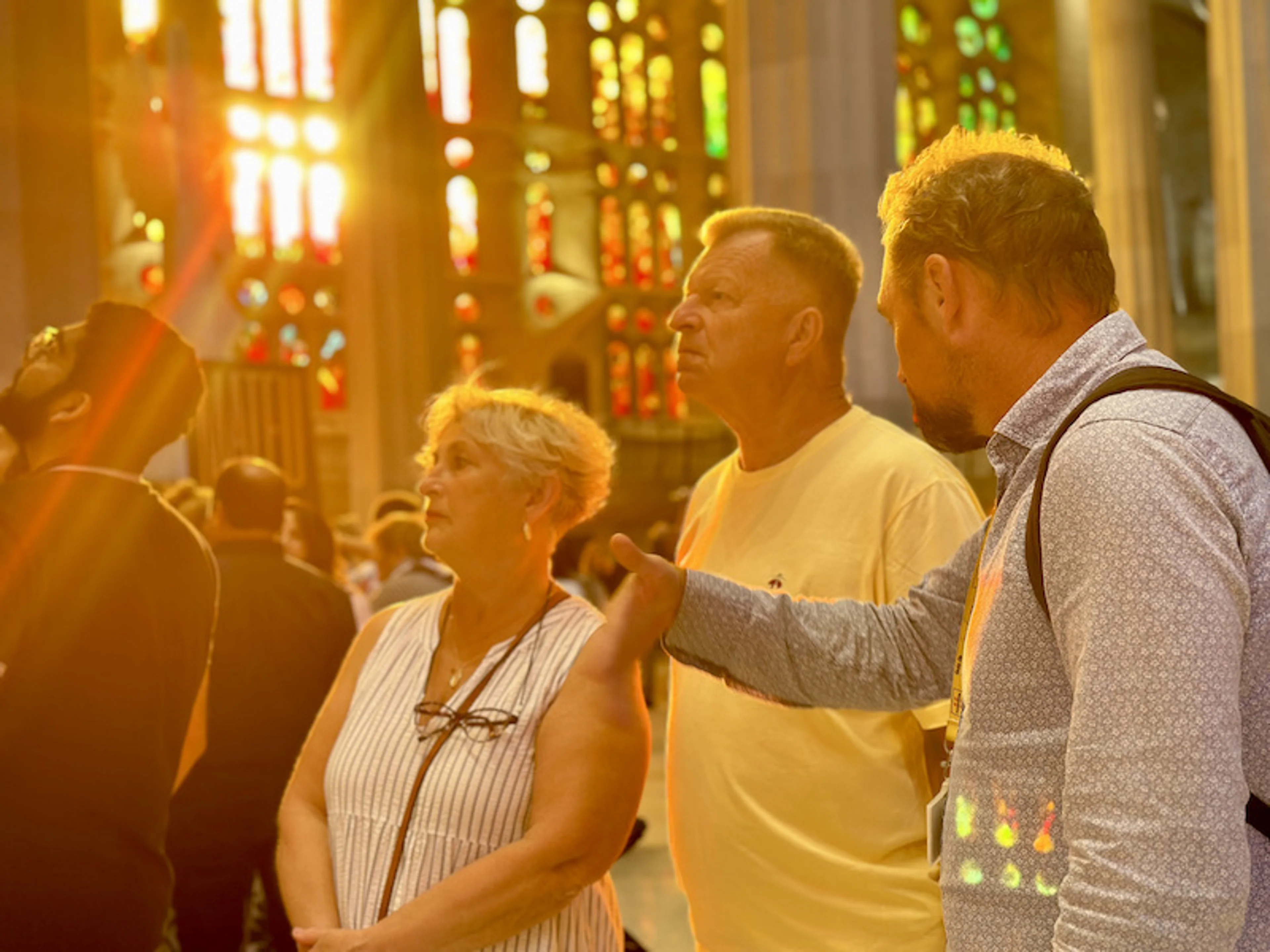 A pair of tourists inside the Sagrada Familia during Golden Hour listening to their guide from The Tour Guy.