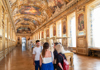 A couple of tourists in the Louvre standing in front of Liberty Leading the People while on tour with The Tour Guy.