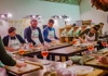 A group of people in aprons preparing food