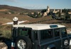 woman and jeep with village in background