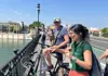 Guided bike tour group stopping on a bridge in Seville’s Triana district as the guide explains the area’s history.