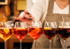 A bartender pouring multiple Spritz in a bar in Venice.