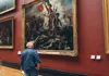 Visitors admiring a large historical painting inside the Louvre Museum