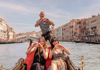 A family sitting on a gondola in Venice.