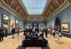 A crowded hall of the National Gallery, London.