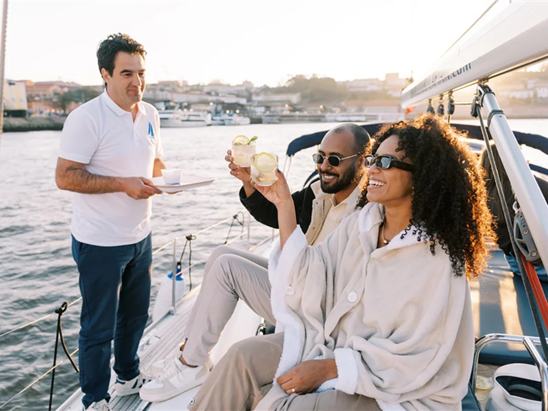 Crew member serving drinks to guests on a private river cruise in Porto
