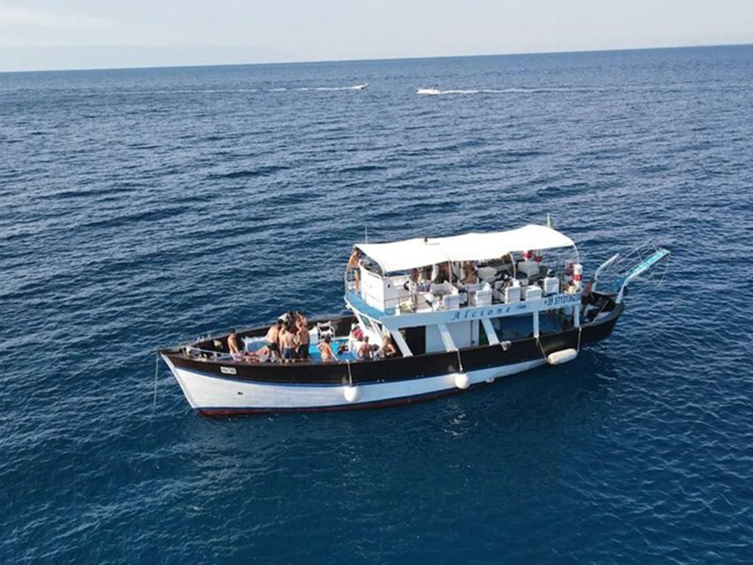 Aerial view of a two-deck excursion boat carrying passengers on open water.
