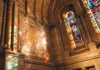 Sunlight illuminating stained glass windows inside a historic Paris church